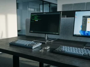 Zwei Tastaturen auf einem dunklen Schreibtisch, getrennt durch ein Vorhängeschloss, symbolisieren sichere Dual-System-Workstation mit Linux und Windows-PC.